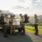 Travelers gather by van for scenic tour