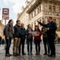 1774253388618_Tour group with guide in Prague city street 85x85