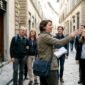 1774428597519_Tour guide leads group on busy city street 85x85