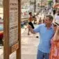 Travelers reading sign in historic city plaza