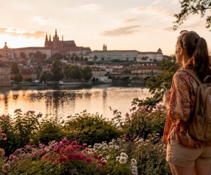 Traveler on Charles Bridge with Prague Castle at sunrise