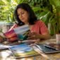 1783606908502_Woman reviewing summer travel plans at kitchen table 85x85