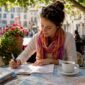 1784307376516_Person planning Europe trip with maps and books 85x85