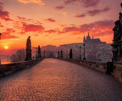 Empty Charles Bridge at sunrise with Prague Castle