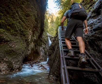 Hiker climbing ladder in Slovak Paradise gorge