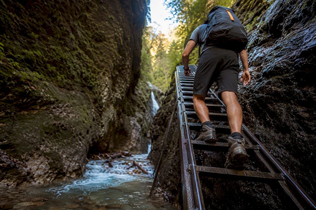 Hiker climbing ladder in Slovak Paradise gorge